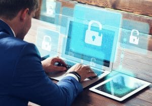 Man typing on a laptop with white lock icon and blue background on screen.